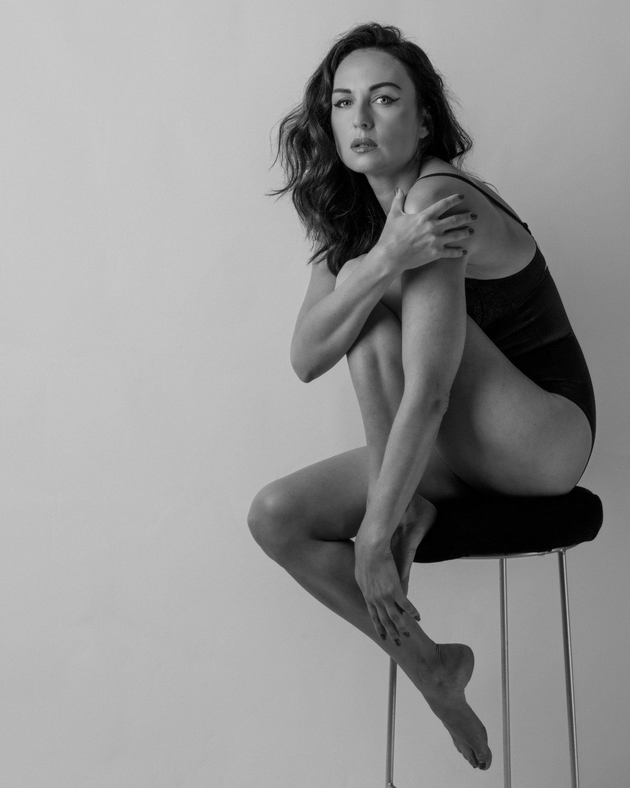 Black-and-white seated studio portrait of a woman posed in shadow and light, from Beauty — Studio Studies I by Jonathan B. Landman.
