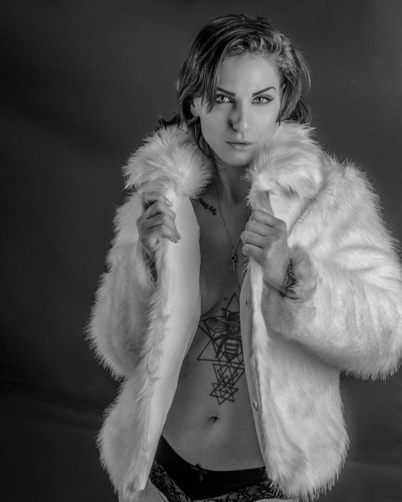 Black-and-white studio portrait of a woman wrapped in white fur, from Beauty — Studio Studies I by Jonathan B. Landman.